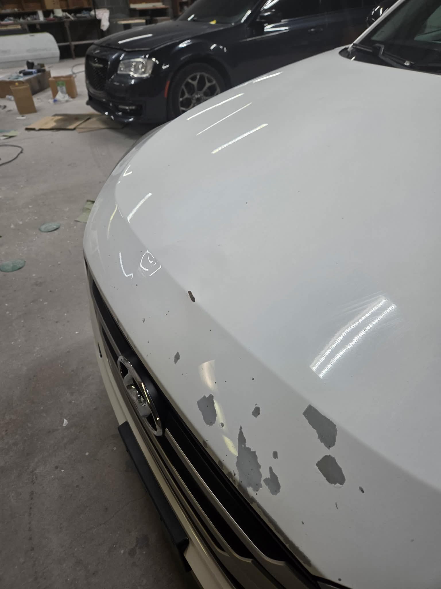 White hood chip repair before paint matching